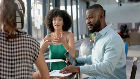 african american businessman discussing with team of colleagues at office