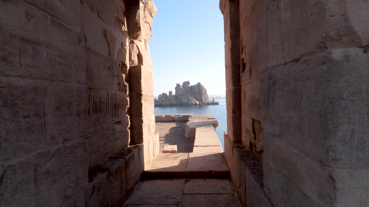 vista de las rocas en el río nilo a través de dos paredes del templo de philae en aswan, egipto
