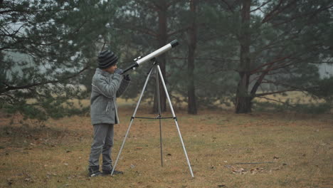 Niño-Mirando-A-Través-De-Un-Telescopio-En-El-Bosque