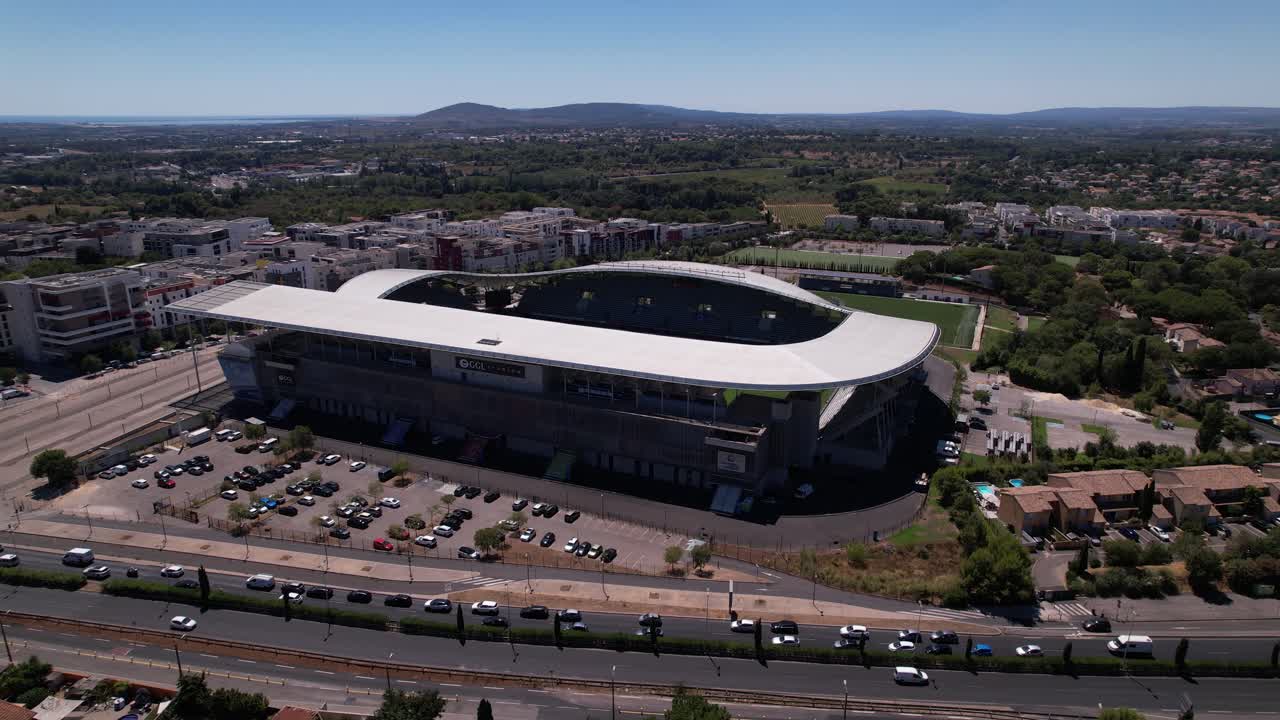 vista aérea del estadio de rugby en montpellier, francia, con un atasco en la carretera frente al estadio.