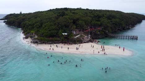 aerial close up drone view of sumilon island white sandbar beach, with tourists swimming in tropical blue clear water, a small island just off the coast of oslob in cebu philippines