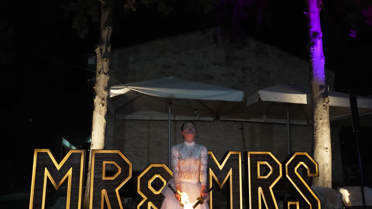 Fire performer at nighttime wedding event under MR and MRS sign