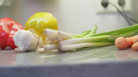 4k-Köstliche-Karotten,-Paprika,-Knoblauch-Und-Lauch-Aus-Frischem-Gemüse,-Die-In-Einer-Küche-Liegen