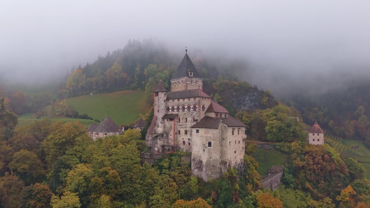 Widok z lotu ptaka na Zamek Trostburg na skalistym alpejskim zboczu, jesienne Dolomity
