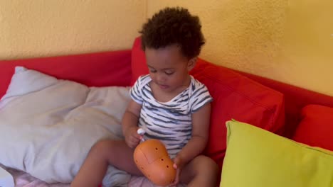 criança afro-europeia bonita de dois anos engraçada e feliz em casa brincando com o sr.