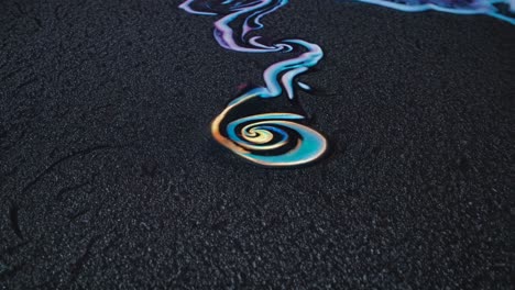 abstract liquid art on dark sand