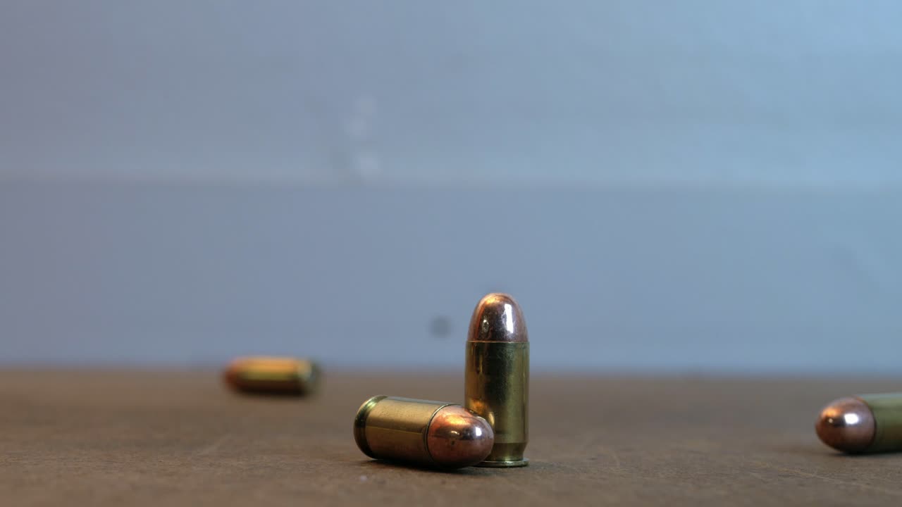 Handgun ammo rolling on the top of a table