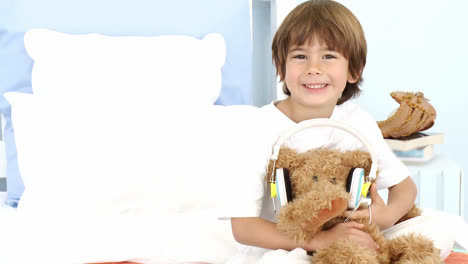 Kleiner-Junge-Und-Teddybär-Hören-Musik-Im-Bett