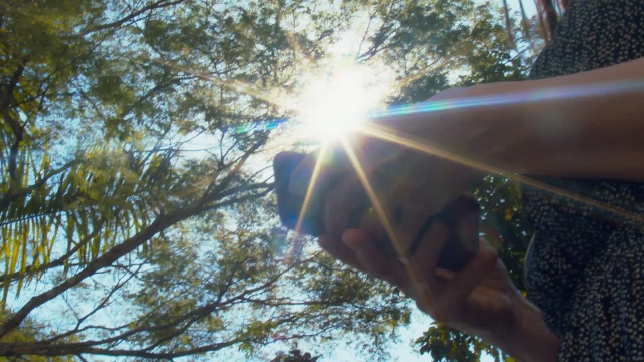 mujer hispana contestando una llamada por teléfono al aire libre, vista de cerca de mano