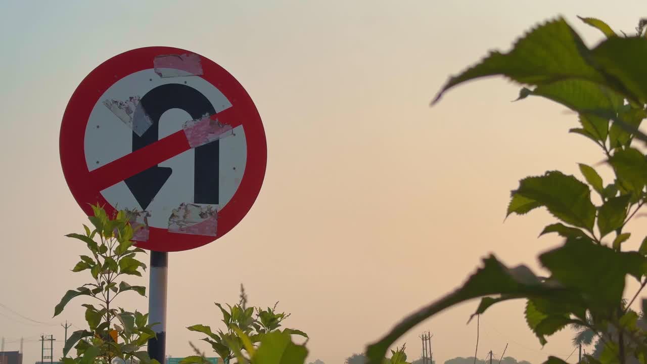 A wide-angle shot capturing a “No U-Turn” traffic sign with a truck passing below during sunset, blending motion, light, and everyday highway life
