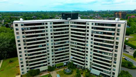 Laval-Quebec-Canadá-Orilla-Del-Río-Edificio-De-Condominios-Blanco-Drone-Dolly-Roll-Paso-Elevado-Día-De-Verano-Con-Vistas-A-Los-Verdes-Jardines-Bosques-Nadie-Afuera-Tranquilo-Alojamiento-En-Casa-De-Retiro-4k60-Bienes-Raíces-Vip