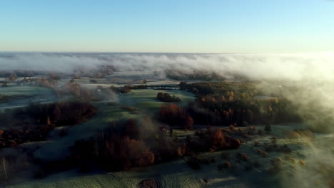 aerial cinematic drone forward view over rural landscape shrouded in fog