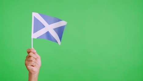 Wind waving a scottish pennant holding by a hand
