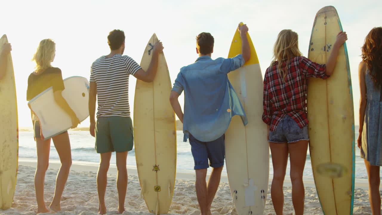 Group of friends holding surfboard
