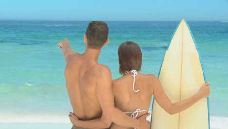 Cute-couple-with-surfboard-looking-at-the-sea