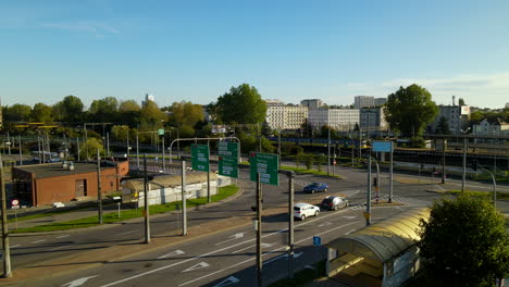 escena diurna en gdynia, polonia - pocos autos en la carretera y tren corriendo en el ferrocarril - disparo de drone descendente, cámara lenta