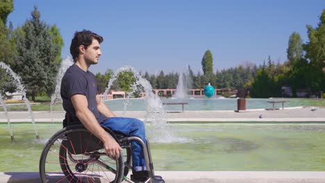 Behinderter-Mann-Sitzt-Und-Geht-Im-Rollstuhl-Im-Park.