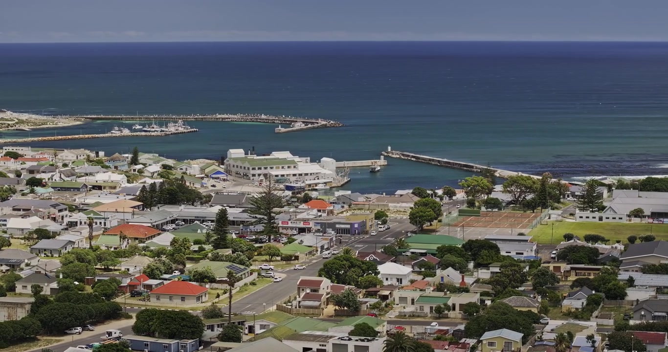 Penerbangan udara telefoto Gansbaai, Afrika Selatan v24 melintasi pusat kota, permukiman penduduk, dan pelabuhan pesisir - Difoto dengan Mavic 3 Pro Cine - 8 Januari 2024