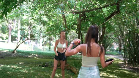 two women playing frisbee in the forest