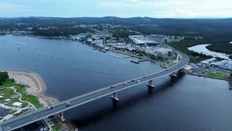 Toma-Aérea-De-Drones-Sobre-La-Autopista-De-Autos-Del-Puente-De-La-Bahía-De-Batemans-Con-Tiendas-De-Pueblos-Rurales-Infraestructura-Comercial-Río-Clyde-Costa-Sur-De-Australia