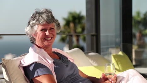 mature woman smiling at camera on balcony