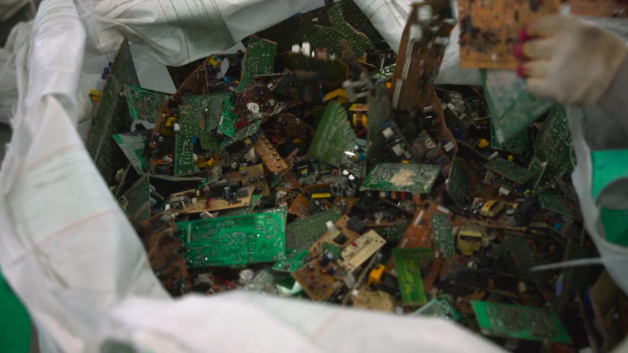 Gloved Hands Sorting Circuit Board Pile, Worker Picking Components From Large Bulk Bag For Manual Inspection