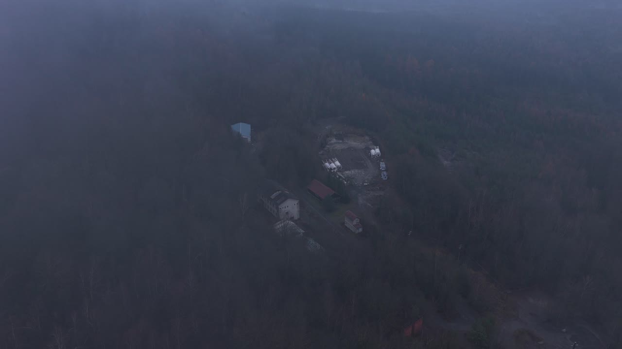 Abandoned mansions and houses in the middle of dense forests in cold, foggy weather. The horror atmosphere evokes fear from the drone's perspective