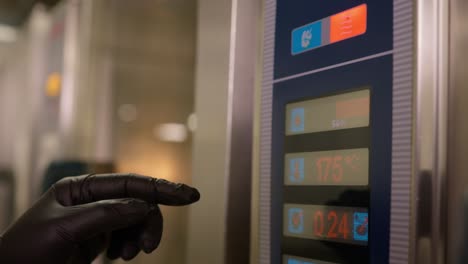 close-up of a person programming the temperature and time of a large technological industrial oven to cook several dishes at the same time