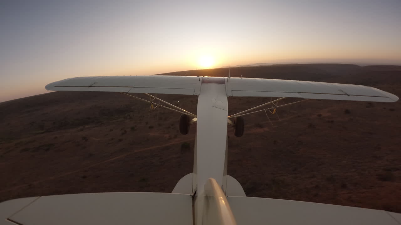 Aereo da boscaglia in volo sopra la savana verso colline ondulate
