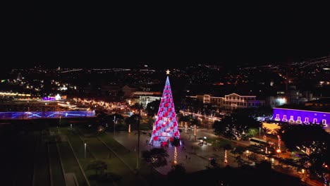 tall light art christmas tree at praça do povo park in madeira during holiday season, aerial