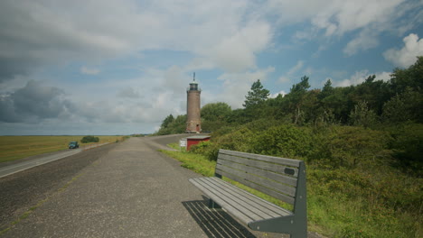 Wide-shot-of-the-Böhler-Lighthouse-near-Sankt-Peter-Ording,-bench-in-the-foreground