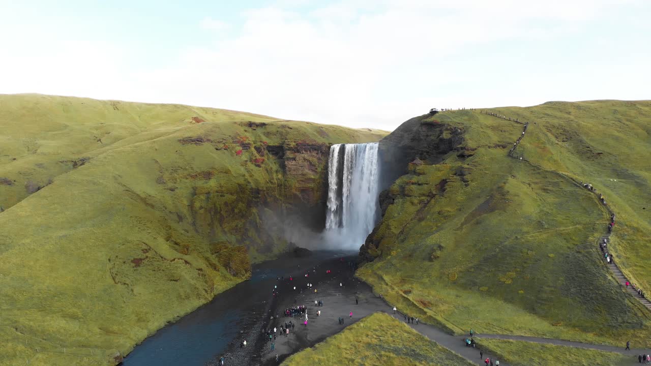 turistas que visitan la famosa cascada de skogafoss en las tierras altas de islandia