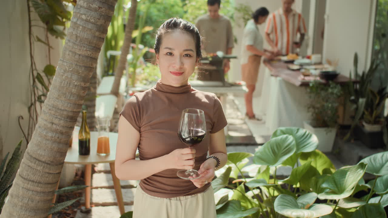 Portrait of Girl Smiling with Glass of Wine during Grill Party with Friends