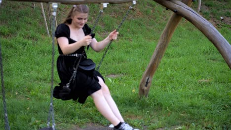 Chica-Con-El-Pelo-Suelto-Se-Balancea-En-Un-Columpio,-Alegría-Juvenil-Despreocupada-En-Un-Día-De-Verano-En-El-Parque