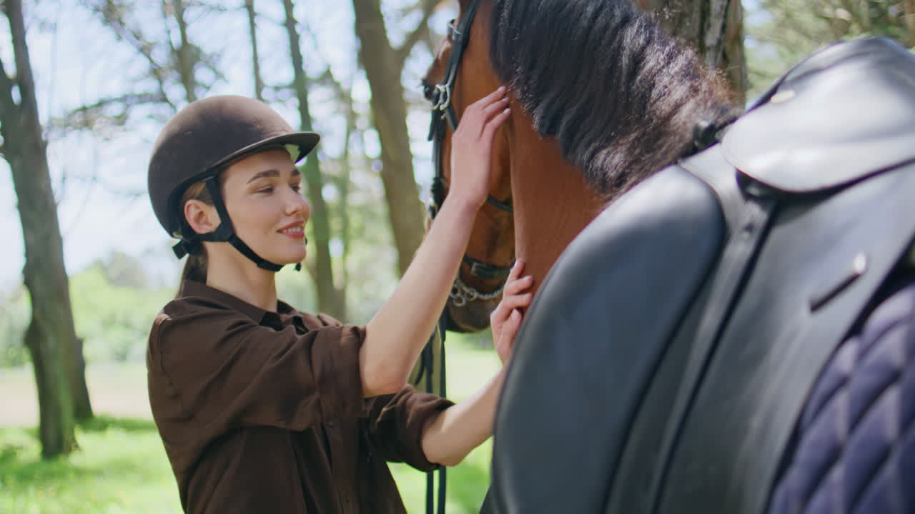 Happy woman petting horse at garden closeup. Smiling lady jockey caressing mare
