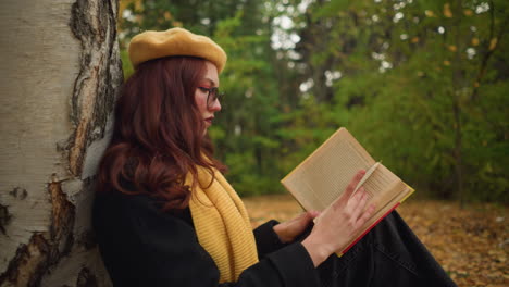 high school student sits in solitude, immersed in book, flipping to next page in peaceful, nature-filled setting, surrounded by autumn leaves, she embraces quiet reflection and deep focus