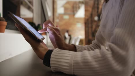 Mid-section-of-creative-businesswoman-using-digital-table-in-modern-office