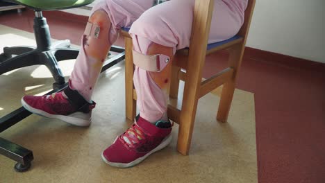 close-up of a child's legs with orthopedic braces and sneakers