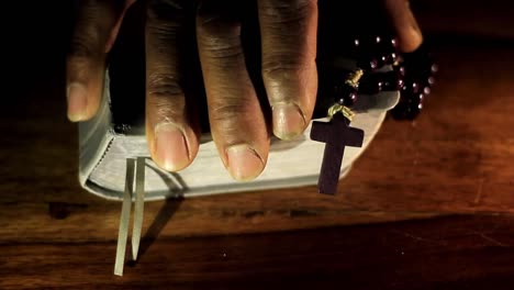 praying to god with hands together with bible and cross caribbean man praying with black background stock video