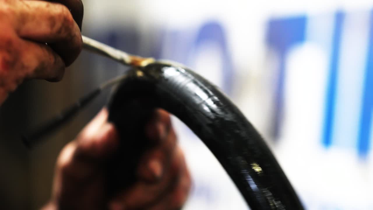 trabajador aplicando pegamento en un tubo de bicicleta
