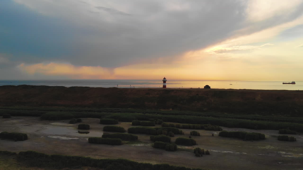 plano general dramático de un faro durante una puesta de sol