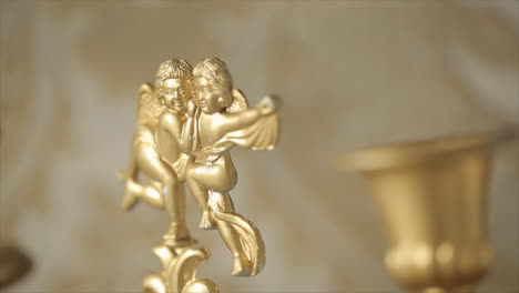 ornate gold candle holder with cherub figures