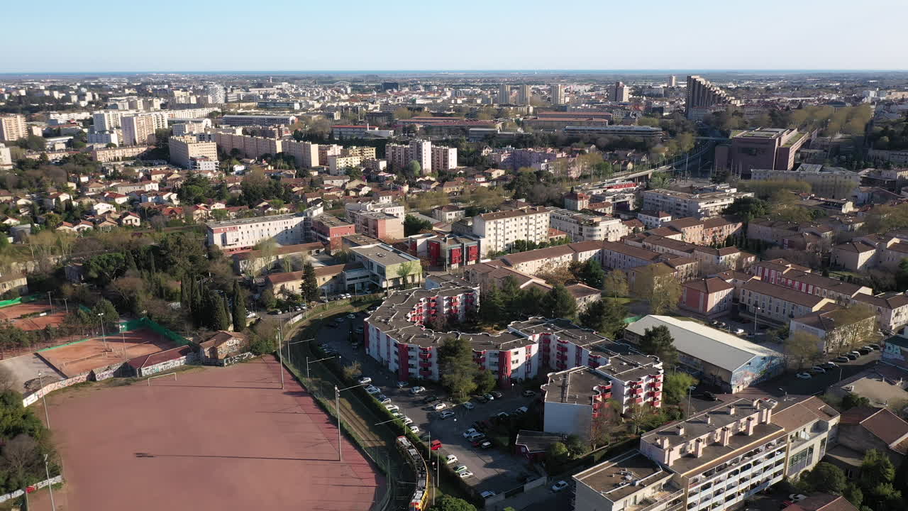 Vista aerea del quartiere Beaux Arts di Montpellier che segue un tram, con la città.