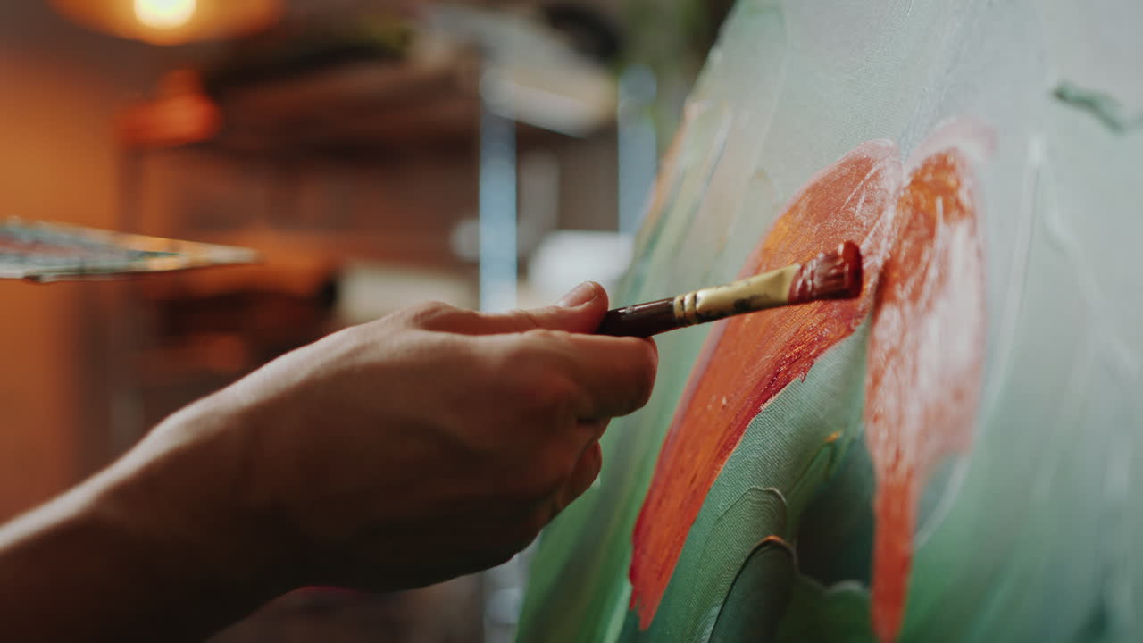 Detailed View of Artist Applying Orange Paint with Brush to Canvas