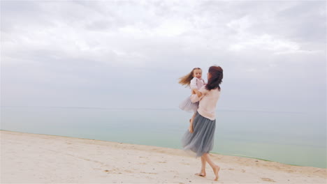 Cheerful-And-Carefree-Mother-Playing-With-Her-Daughter-On-The-Beach