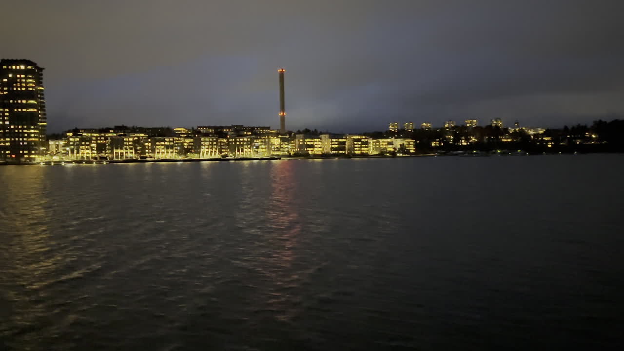 우현 쪽 작은 도시의 항구에 접근하는 밤 시간에 보트로 여행