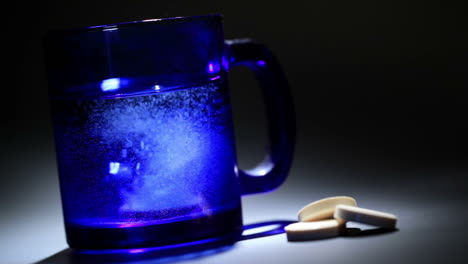 Tablet dissolving in a blue glass of water