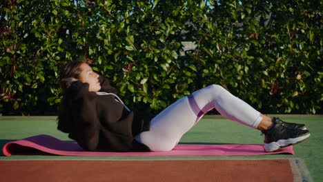 mujer haciendo abdominales al aire libre