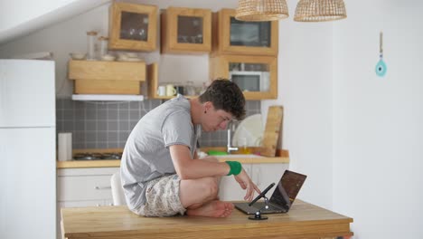 joven trabajando en una computadora portátil en una cocina