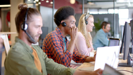 happy biracial casual businessman and diverse colleagues using phone headsets, slow motion